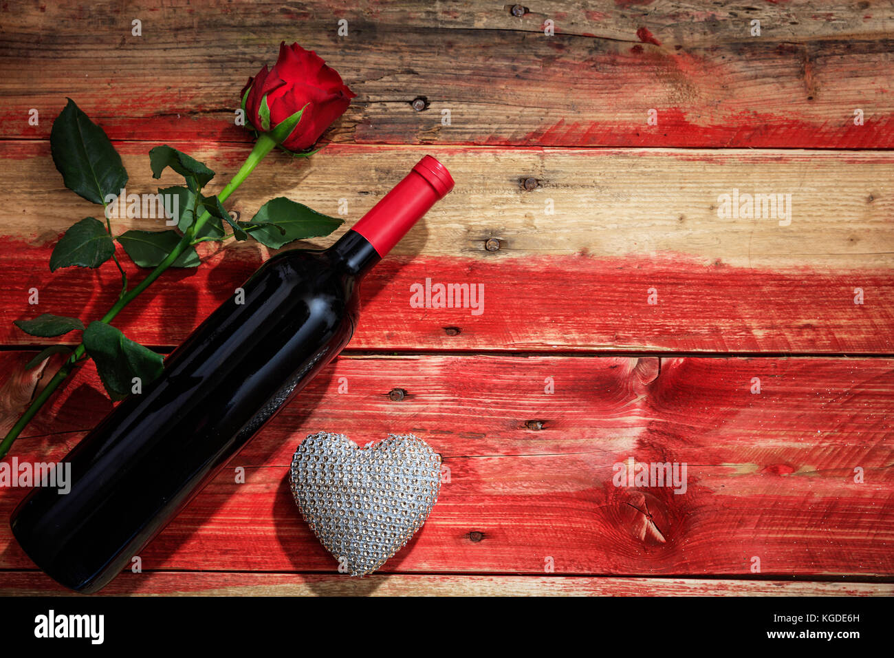 Valentines Tag Konzept. Rotwein Flasche und rote Rose auf Holz- Hintergrund Stockfoto