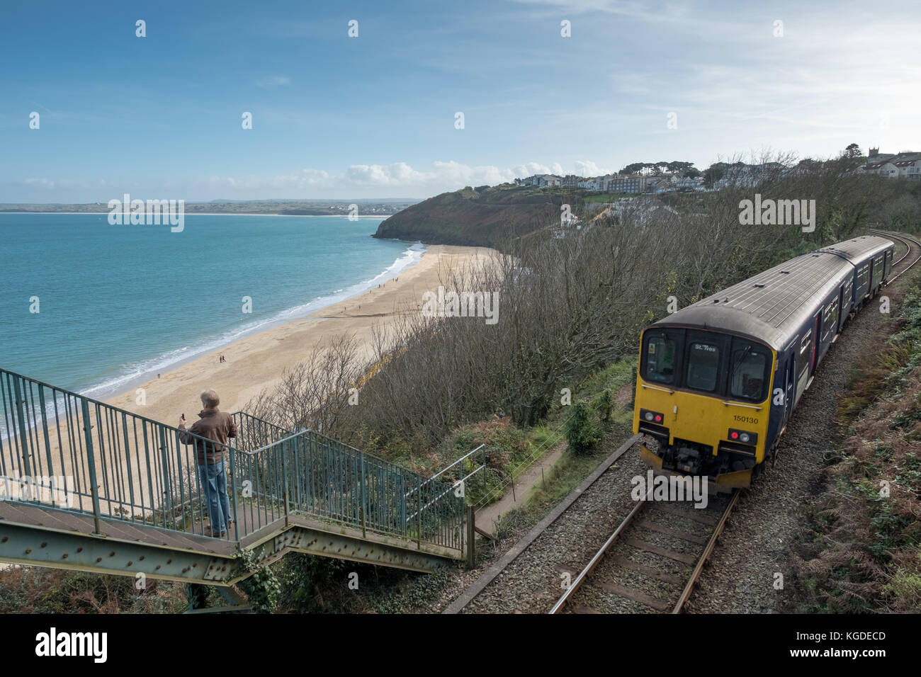 Oktober 2017, ein Tourist macht ein Foto von Carbis Bay in Cornwall als eine Great Western Railway Zug fährt vorbei im Hintergrund Stockfoto