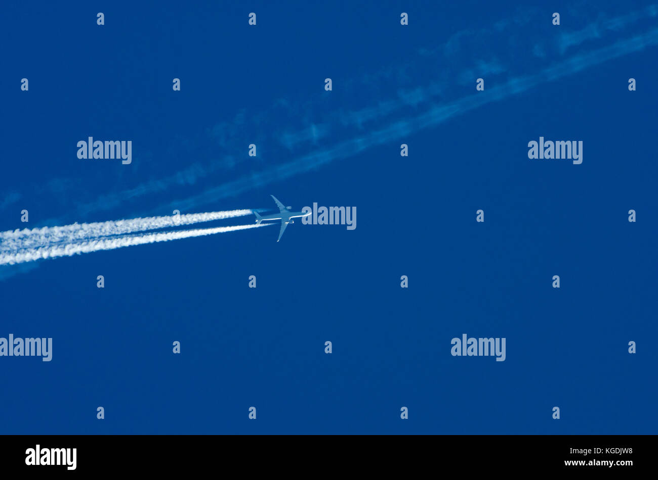 Transport Wettbewerb Konzept: ein Düsenflugzeug Kreuzung weißen Kondensstreifen gegen den blauen Himmel Hintergrund mit Kopie der anderen Ebene Stockfoto
