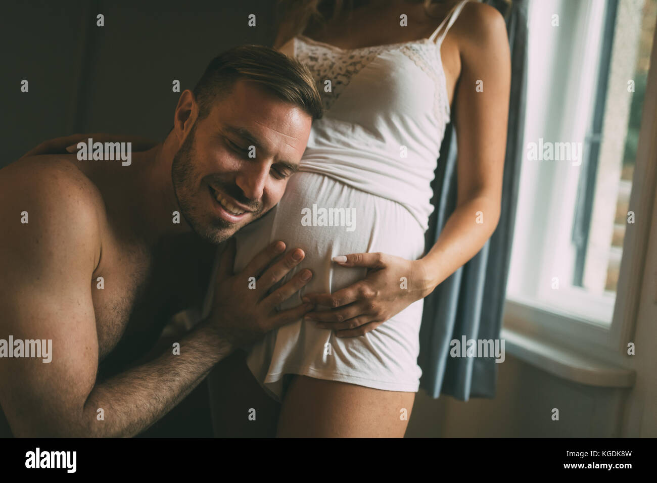Gerne schwangere Frau mit Mann im Schlafzimmer Stockfoto