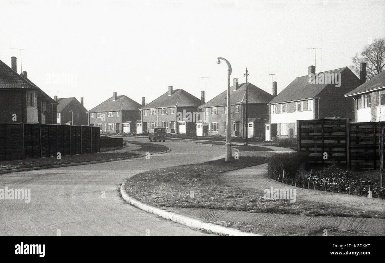 1950, historische, am frühen Morgen und eine Milch schweben auf einer gekrümmten Straße in einem Englischen vorort Wohnsiedlung. Stockfoto