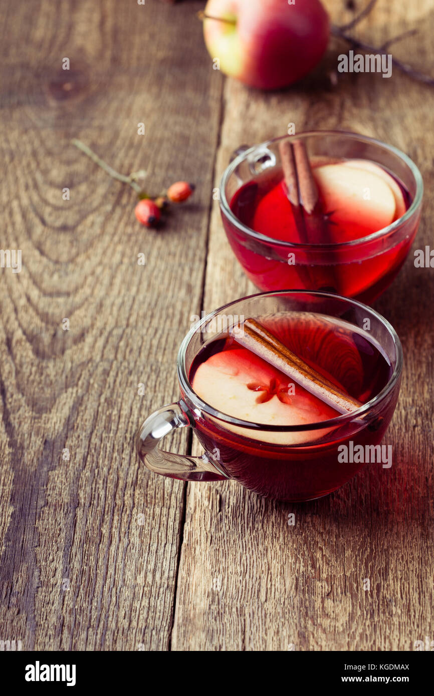 Glühwein mit Apfelscheiben in Glas Becher auf rustikalen Holztisch serviert für zwei Personen Stockfoto