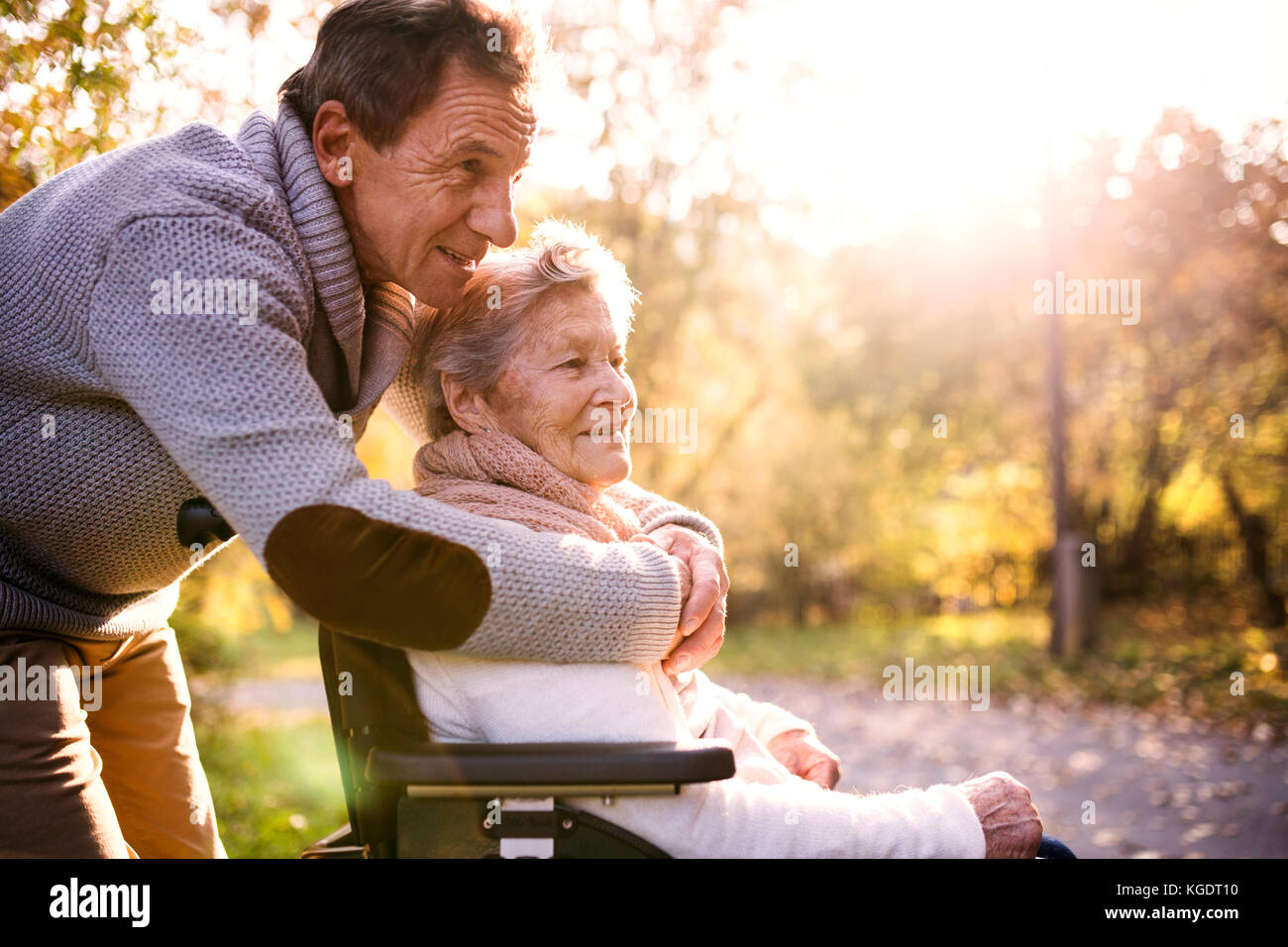 Älterer Mann und Frau im Rollstuhl im Herbst Natur. Stockfoto