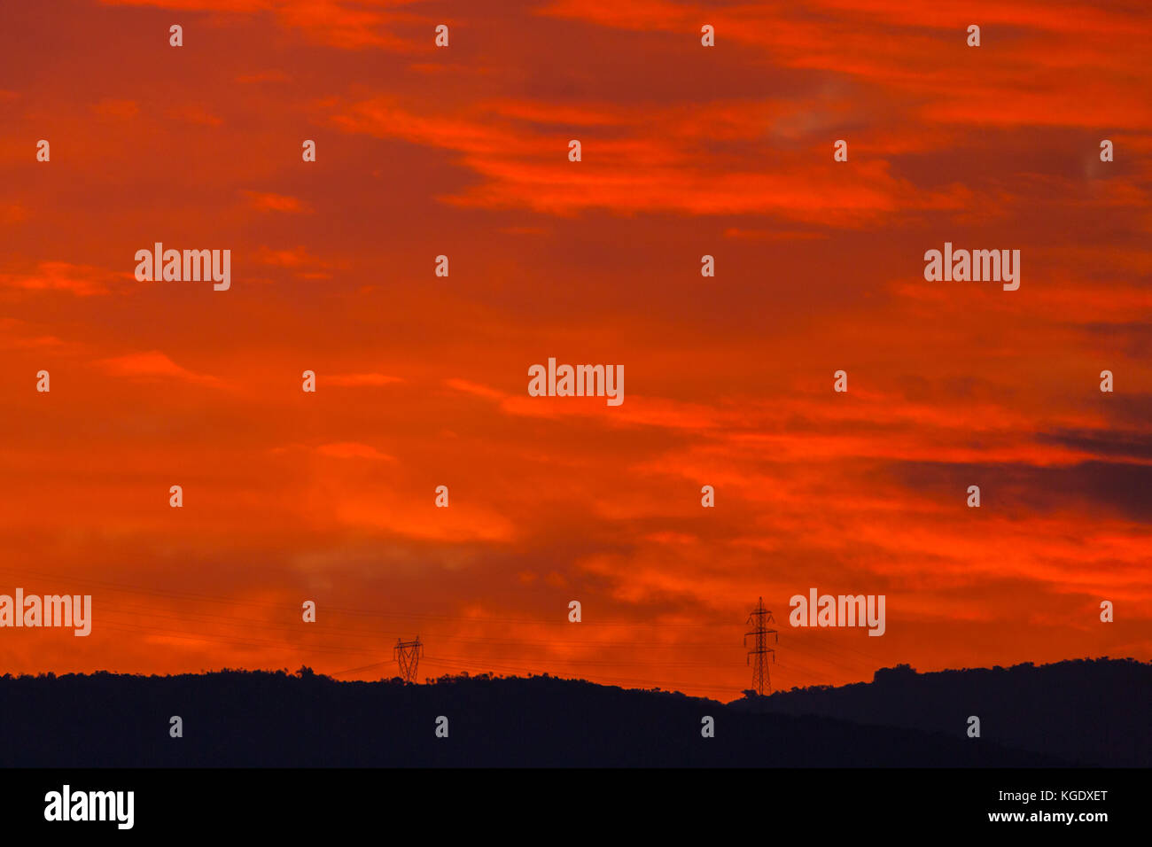 Zwei Strommasten in natürlichen Sonnenuntergang Red Sky Stockfoto