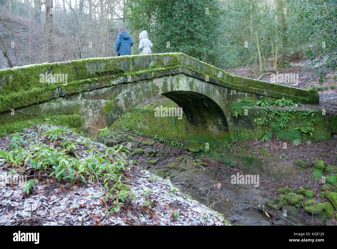 Sheffield, UK-Jan 2015: Zwei Kinder spielen auf packesel Brücke über Tinker Bach am 18 Jan 2015 in Glen Howe Park, in der Nähe von Wharncliffe Seite Stockfoto