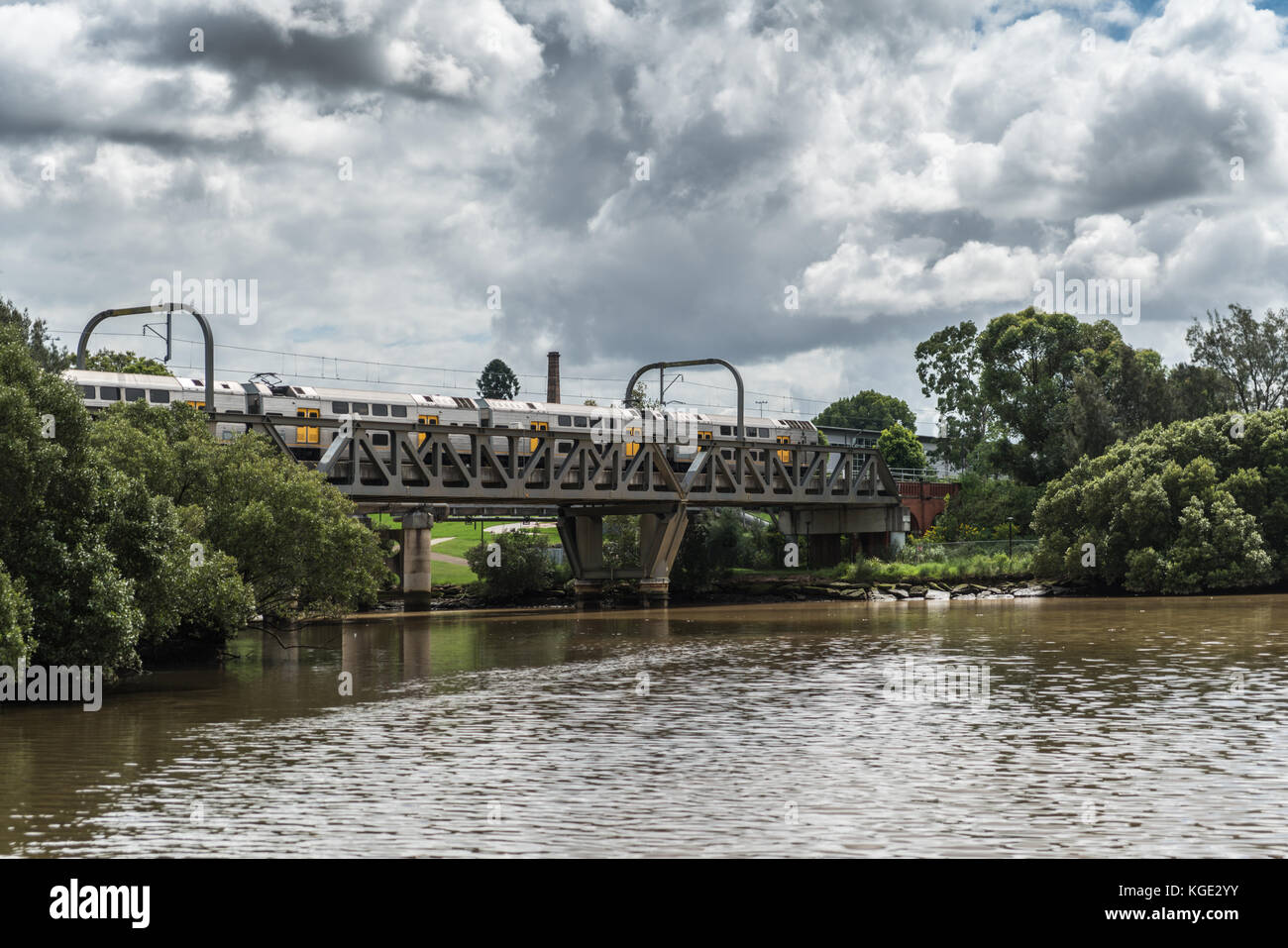 Parramatta, Australien - März 24, 2017: Zug um Zug Brücke über den Parramatta River nahe der Stadt unter schweren cloudscape. grün Stockfoto