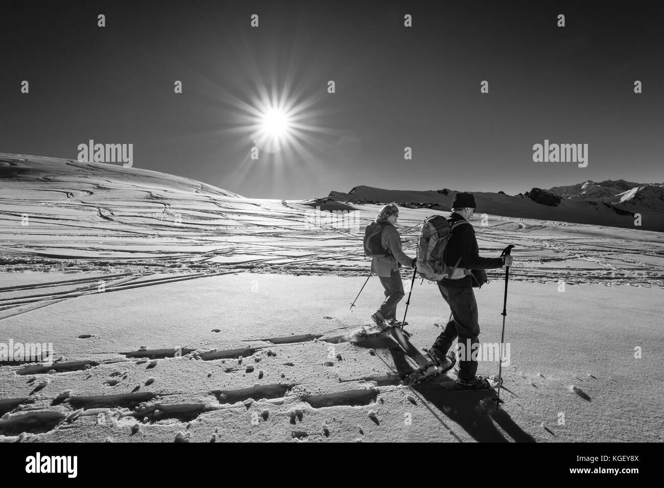 Senior Paar ist Schneeschuhwandern durch alpine Winter Berge bei Sonnenuntergang. Bayern, Deutschland. Stockfoto
