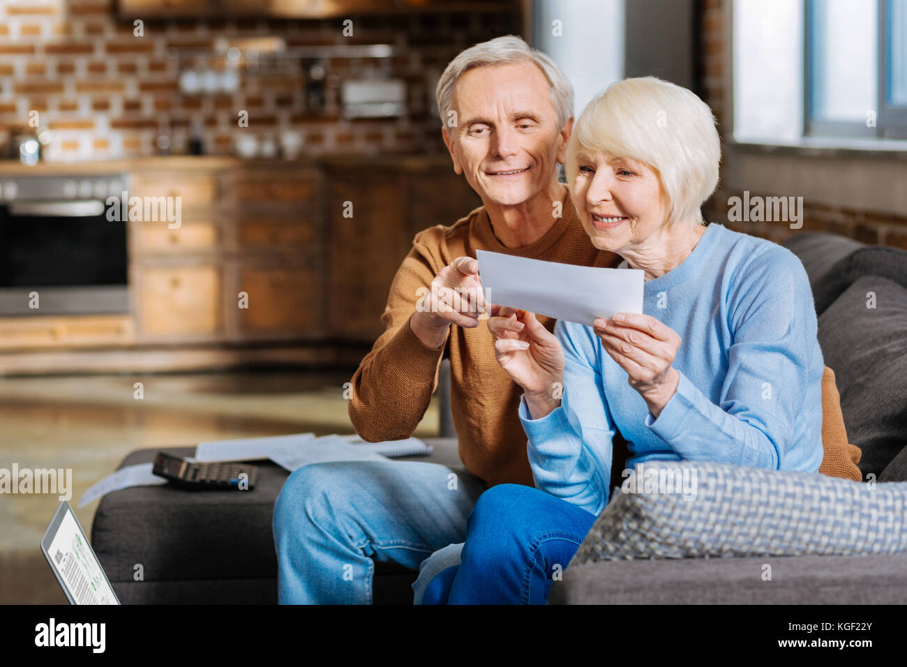 Positive gealterte Ehepaar auf dem Sofa sitzt. Stockfoto