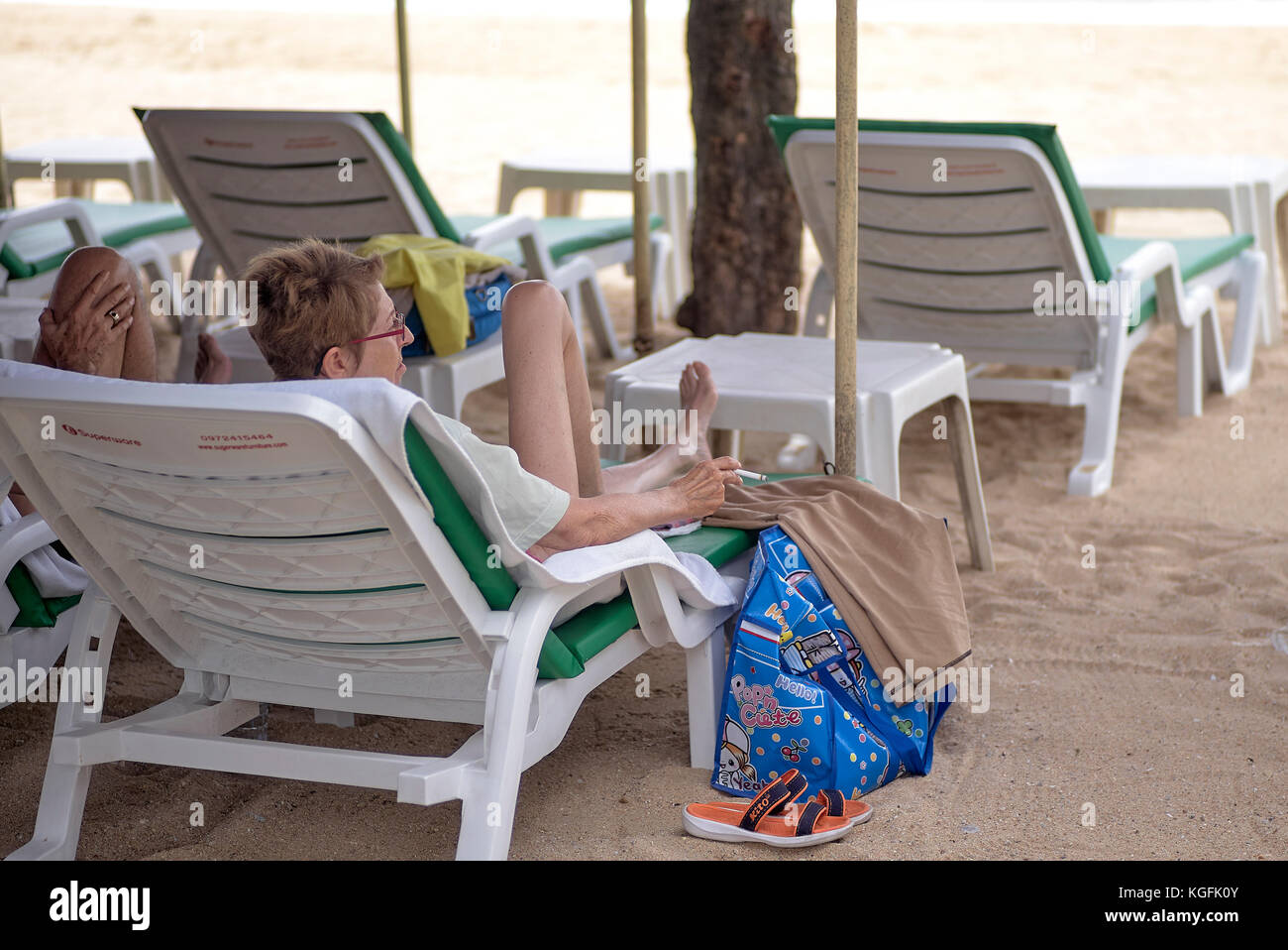 Frau, die eine Zigarette an einem Strand in Thailand raucht. Die Regierung hat Gesetze gegen diese Verhängung von Geldstrafen und mögliche Freiheitsstrafen verabschiedet Stockfoto