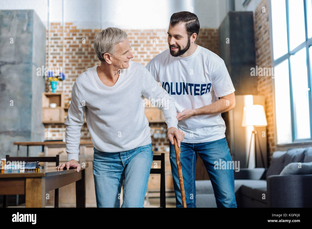 Angenehmer junger Mann, eine echte Unterstützung für eine einsame Rentner Stockfoto
