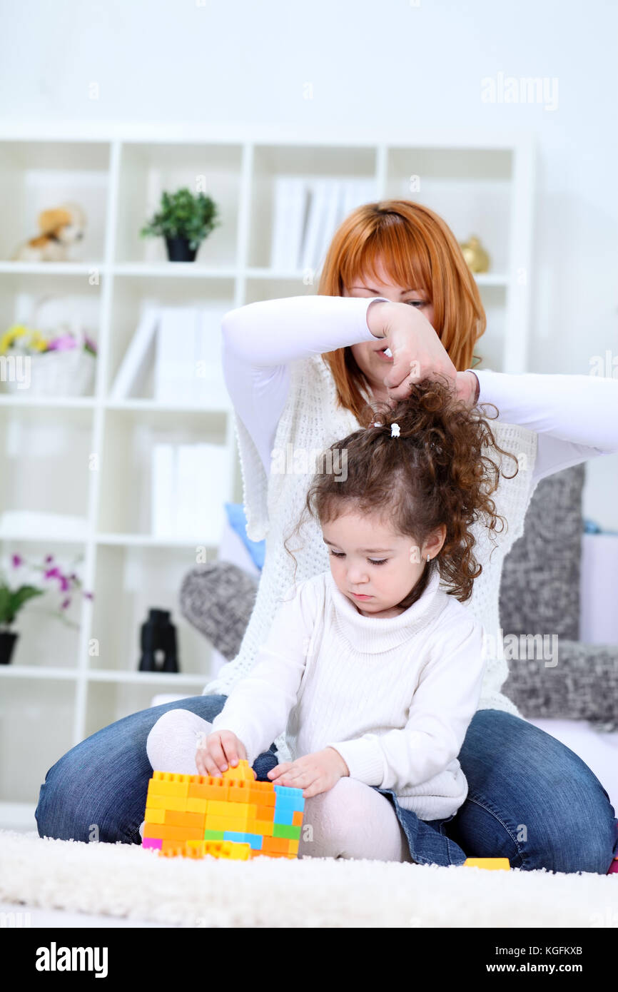 Mutter zur Festsetzung Töchter Haar zu Hause Stockfoto