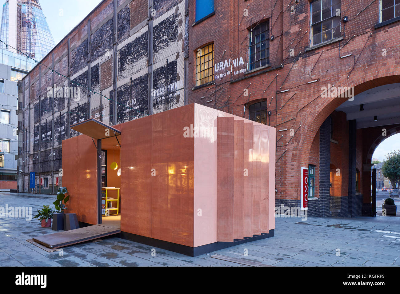 Temporärer Pavillon im Kontext in der Abenddämmerung. Der Stack - Mini Living Urban Kabine, London, Vereinigtes Königreich. Architekt: Sam Jacob Studio, 2017. Stockfoto