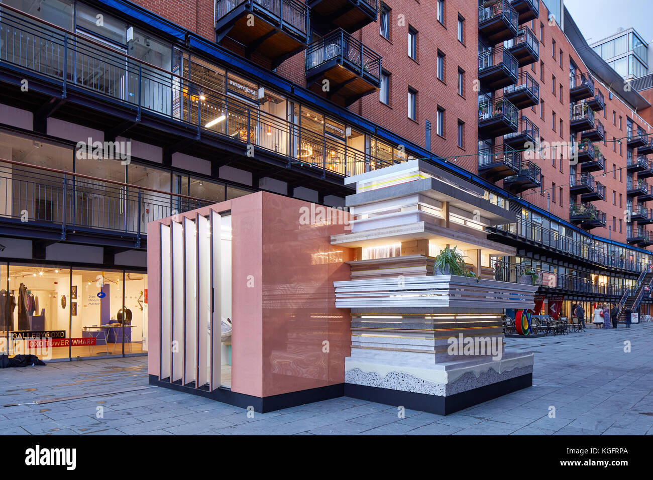 Temporärer Pavillon im Kontext in der Abenddämmerung. Der Stack - Mini Living Urban Kabine, London, Vereinigtes Königreich. Architekt: Sam Jacob Studio, 2017. Stockfoto