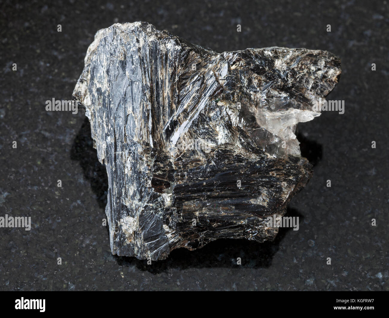 Makroaufnahmen von natürlichen Mineralgestein Muster - raw gedrite Stein auf dunklem Granit Hintergrund aus yelovyy shuyeretskoe navolok (Mine), Karelien, russ Stockfoto
