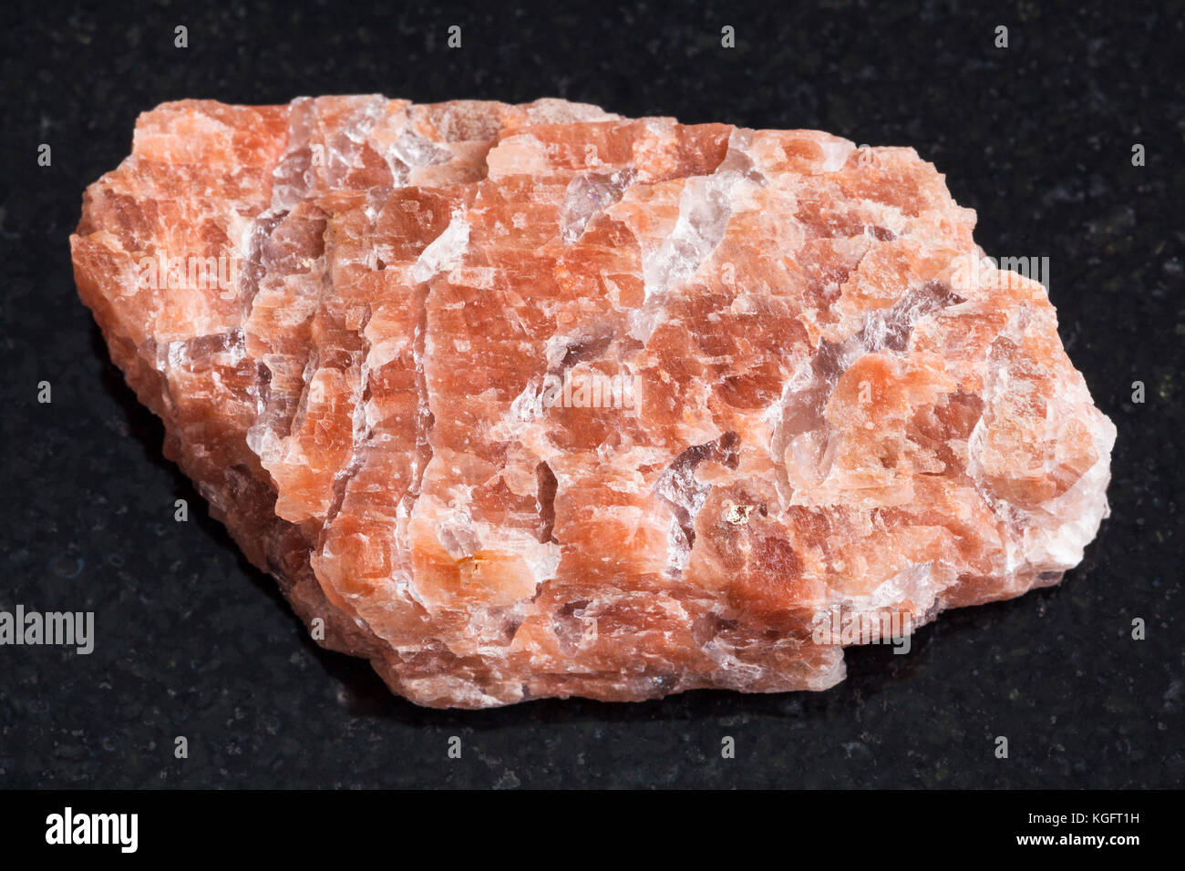 Makroaufnahmen von natürlichen Mineralgestein Muster - raw pegmatite Stein auf dunklem Granit Hintergrund aus urakko steht Region, Karelien, Russland Stockfoto