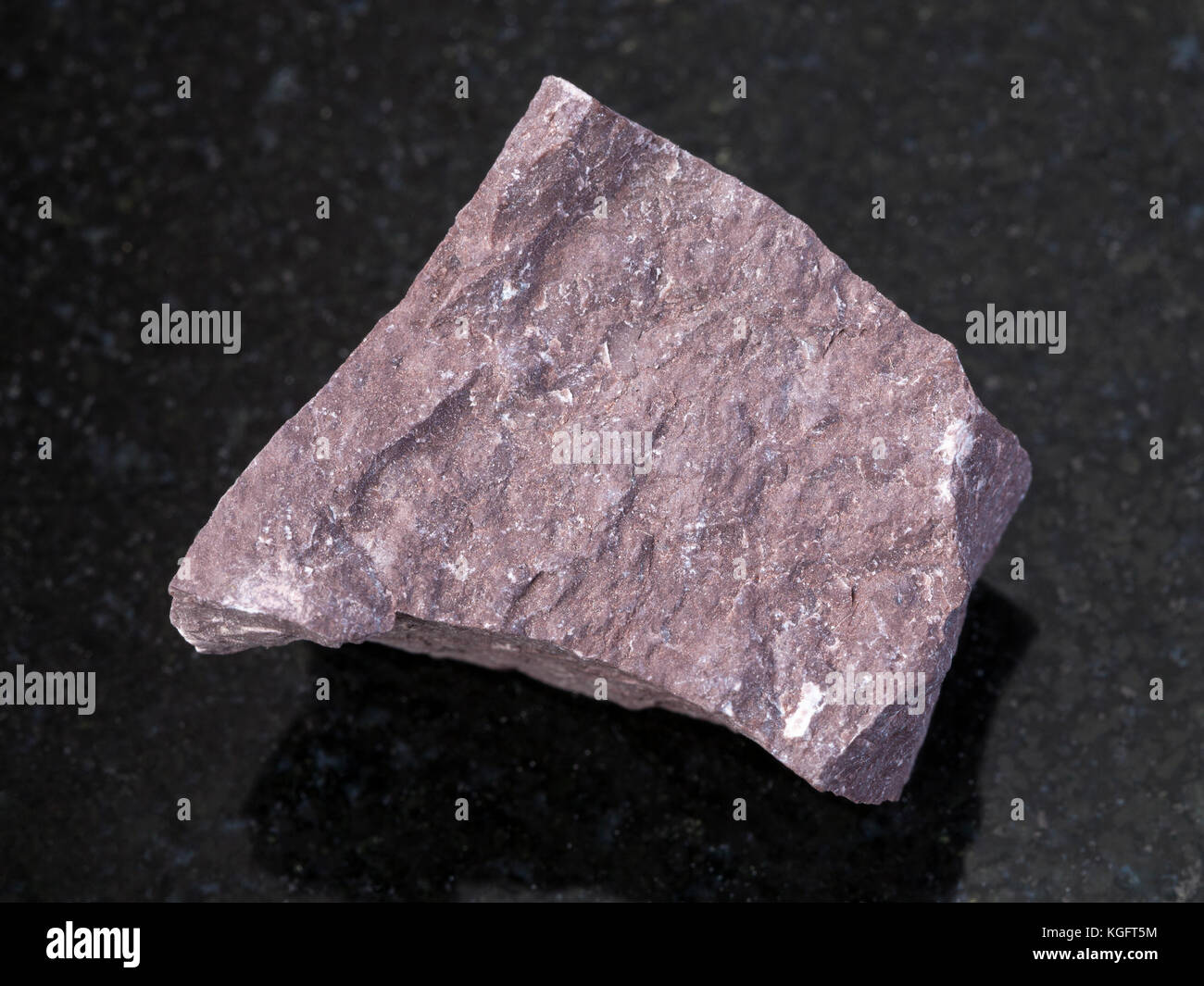 Makroaufnahmen von natürlichen Mineralgestein Muster - Grobe aleurolite Stein auf dunklem Granit Hintergrund Stockfoto