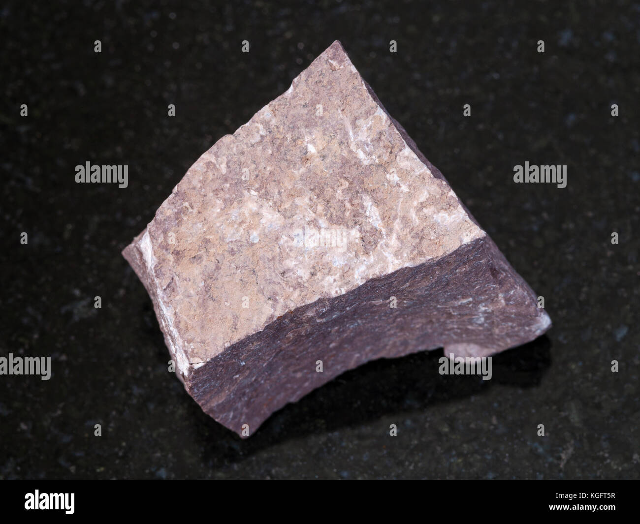 Makroaufnahmen von natürlichen Mineralgestein Muster - raw aleurolite Stein auf dunklem Granit Hintergrund Stockfoto