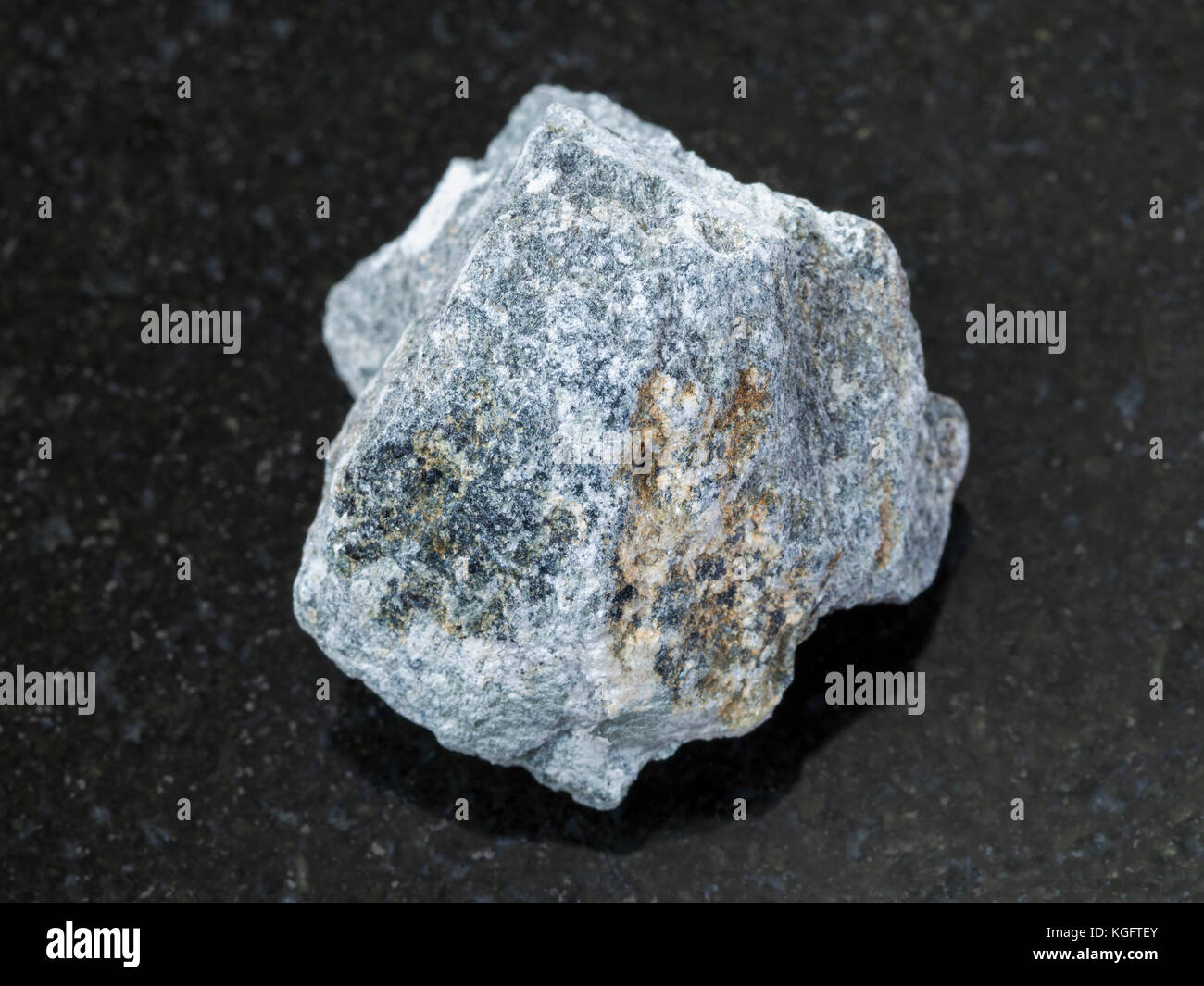 Makroaufnahmen von natürlichen Mineralgestein Muster - grobe Speckstein Stein (talkum - Schiefer) auf dunklem Granit Hintergrund Stockfoto