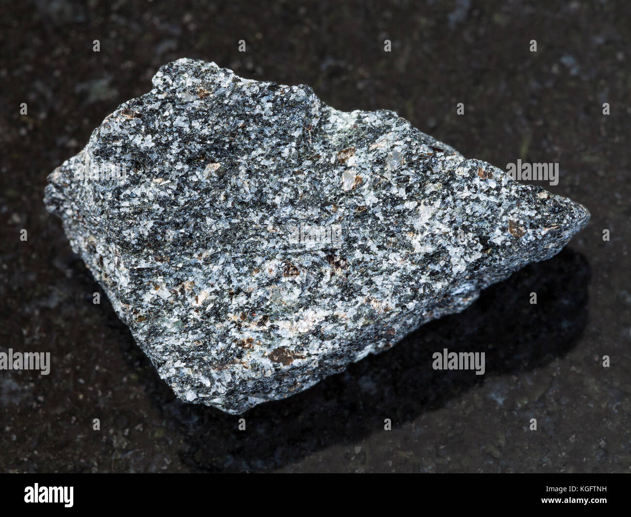 Makroaufnahmen von natürlichen Mineralgestein Muster - grobe Nephelinsyenit Stein auf dunklem Granit Hintergrund Stockfoto