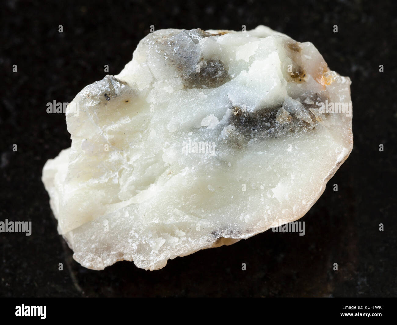 Makroaufnahmen von natürlichen Mineralgestein Muster - raw Talkum Stein auf dunklem Granit Hintergrund von Irkutsk Region Stockfoto