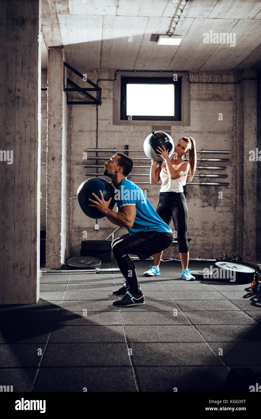 Junge muskulöse Paar trainieren gemeinsam in der Turnhalle. Stockfoto