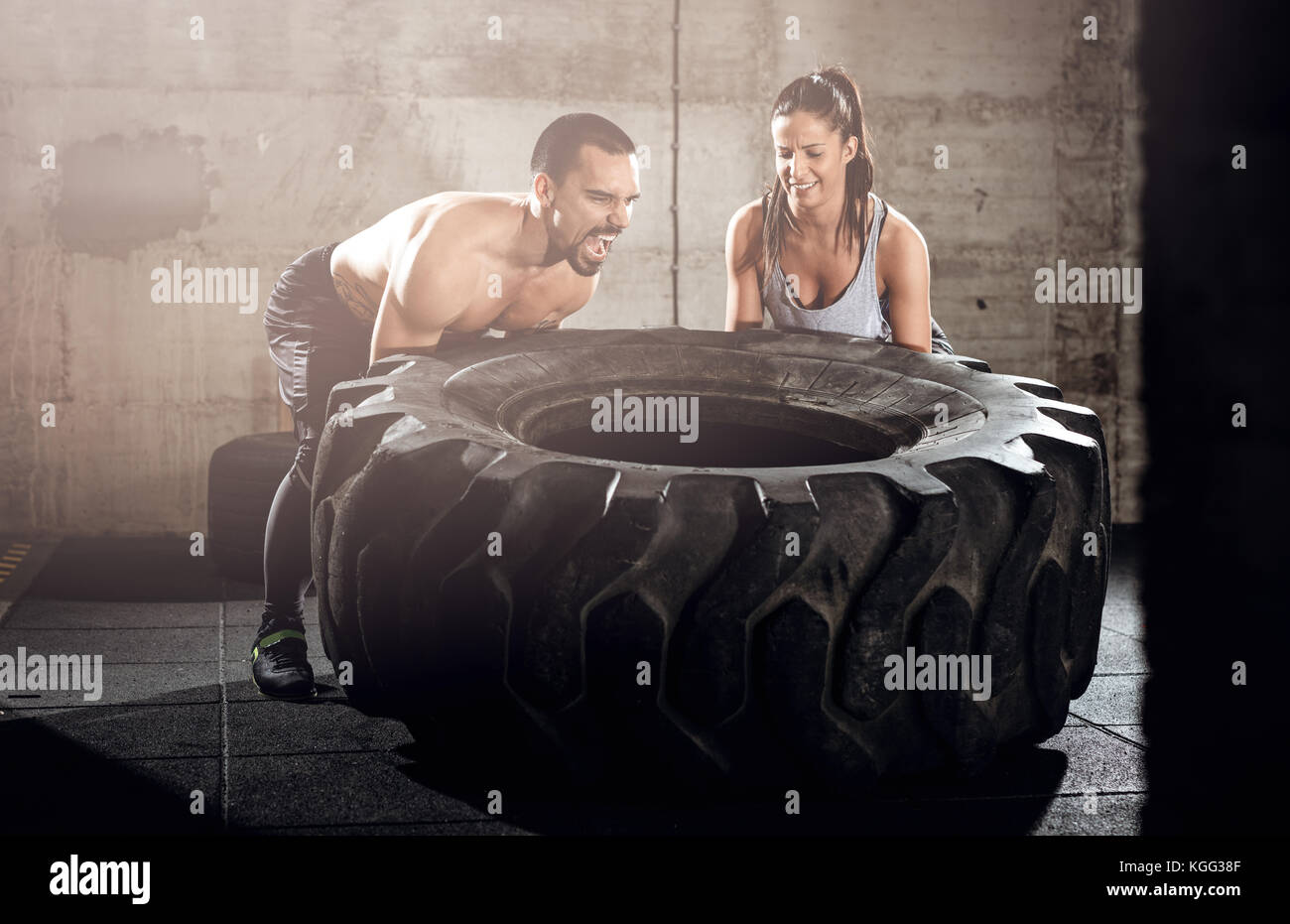 Junge muskulöse Paar spiegeln ein Reifen am Kreuz fit Training im Fitnessstudio. Stockfoto