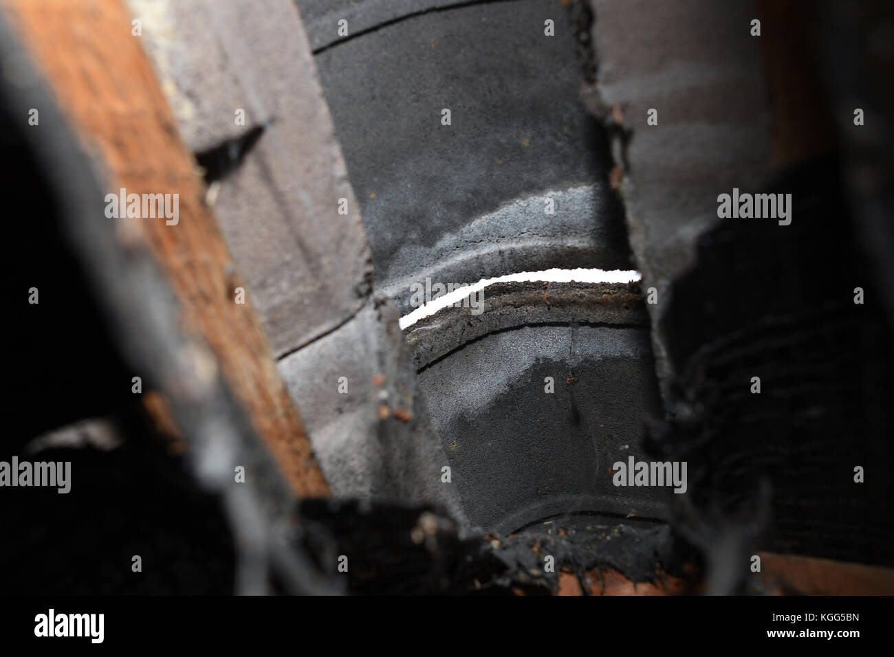 Eine Bohrung in zwischen Firstziegel auf Haus Dach von unten innen Dachboden gesehen nach Moos weg an Beton frisst. Stockfoto
