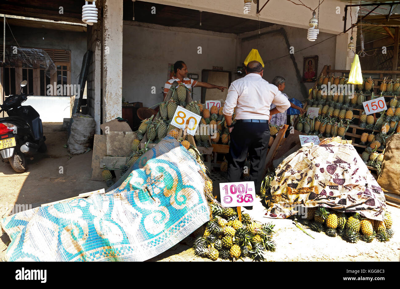 North Western Provinz Sri Lanka Mann kaufen Ananas vom Abschaltdruck Halter Stockfoto