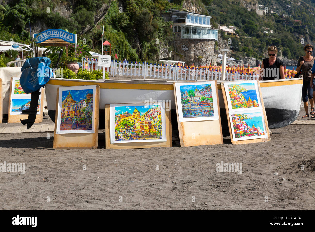 Kunst zum Verkauf gegen ein Boot auf den Strand von Positano, Italien angezeigt. Stockfoto
