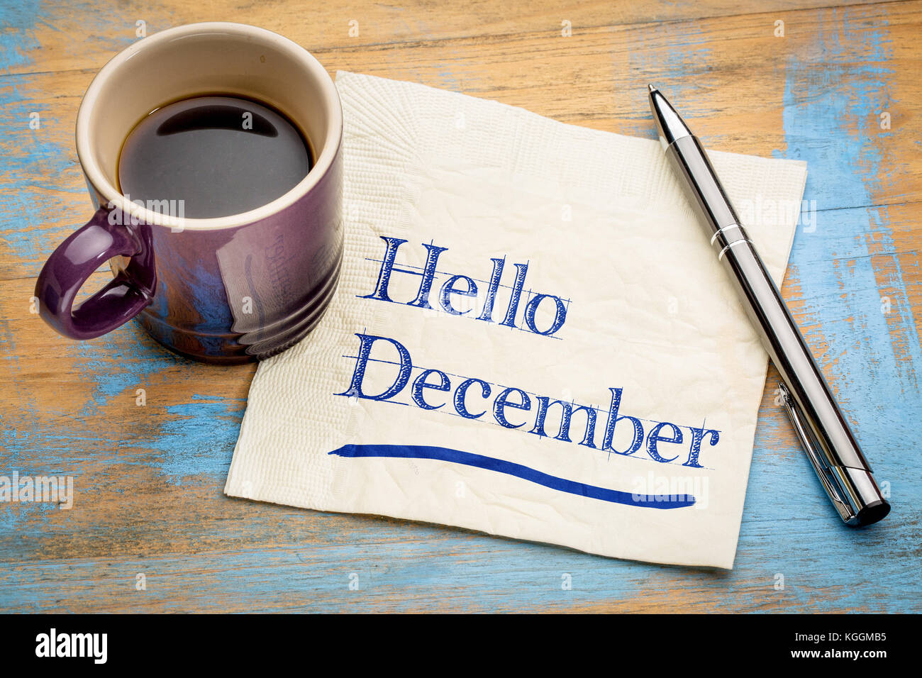 Hallo Dezember - Handschrift auf eine Serviette mit einer Tasse Espresso Stockfoto