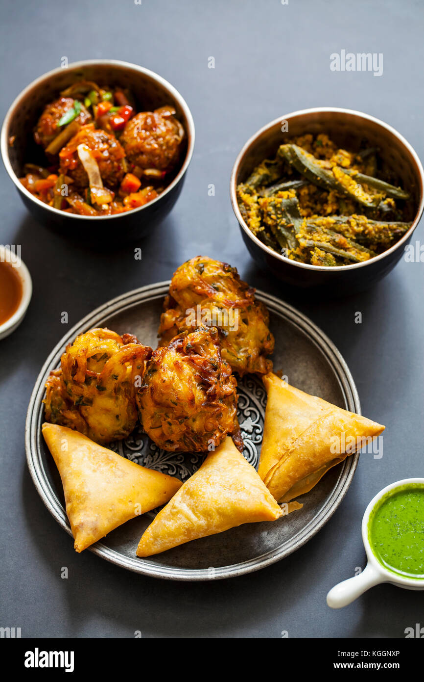 Auswahl indischer Gerichte: Samosas, Zwiebel Bhaji, manchurian Kugeln und Okra Stockfoto