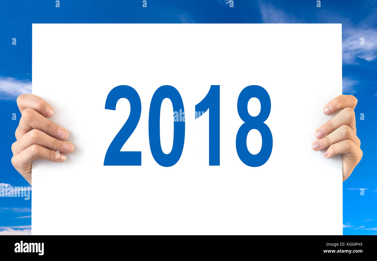 Hände halten eine weiße Tafel mit 2018, blauer Himmel Hintergrund Stockfoto
