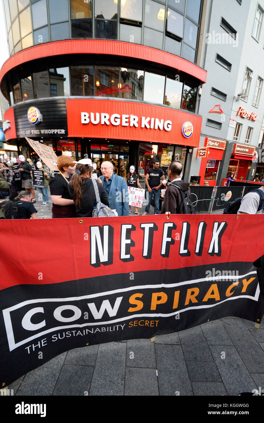 Tierschützer außerhalb der Burger King in Leicester Square, London protestiert. Geändert Netflix banner Cowspiracy Stockfoto