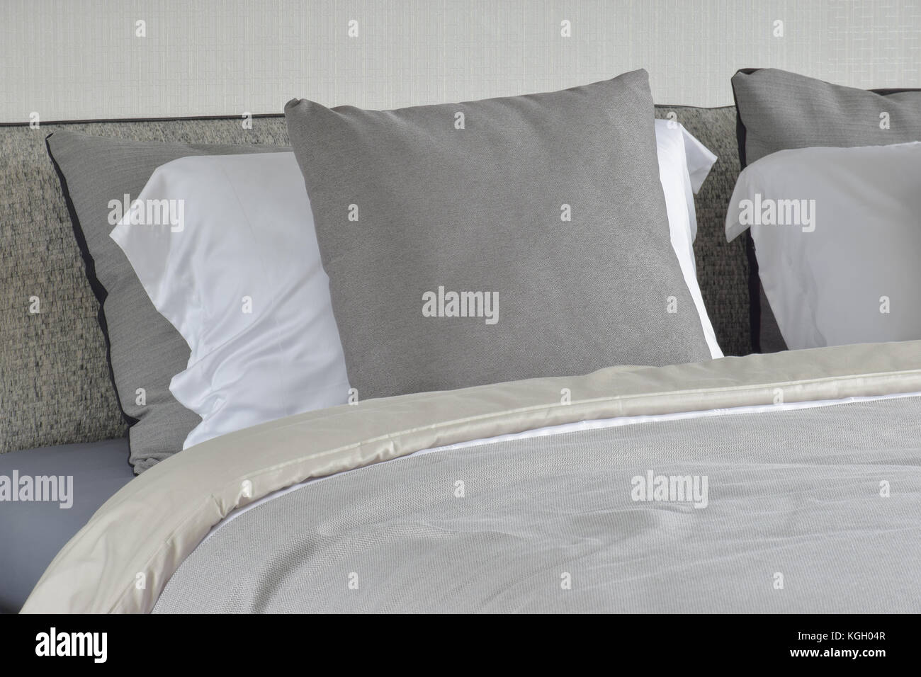 Grau Kissen auf weißen Einstellung auf dem Bett mit bequemen Decke Stockfoto