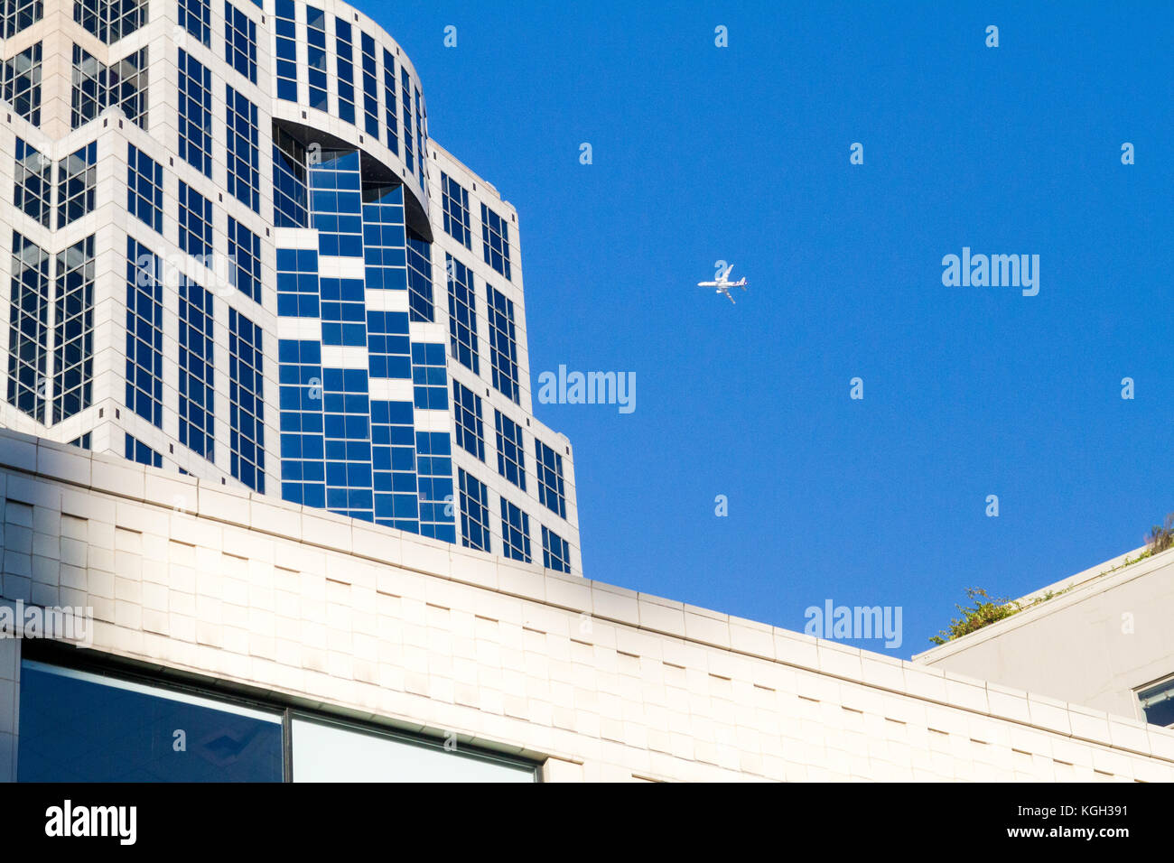 Blick auf die Straße von US-Bank Gebäude in Seattle, Washington mit Jet Flugzeug fliegen über in einem klaren, blauen Himmel. Stockfoto