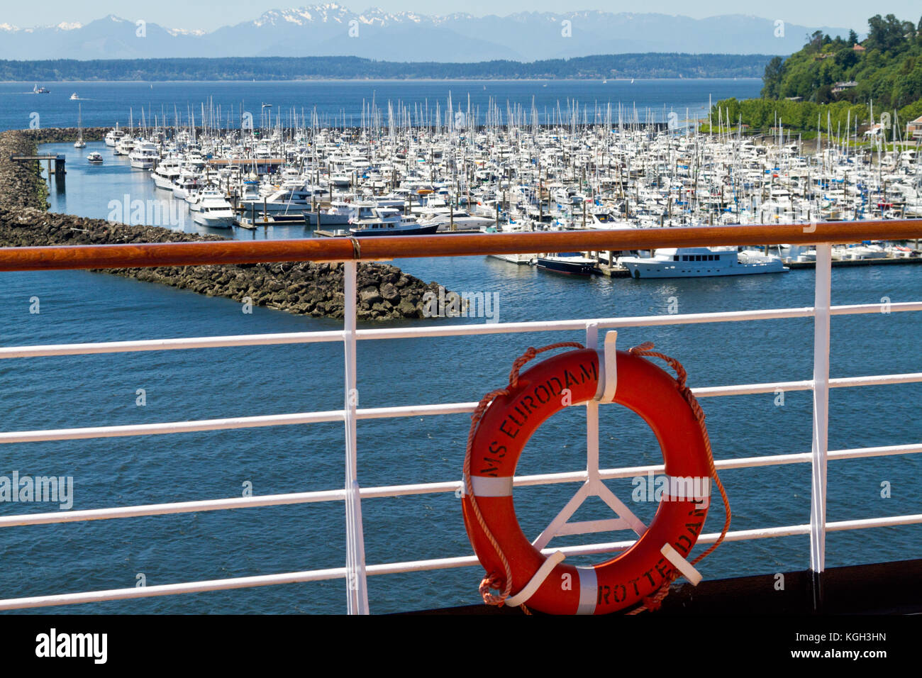 Eine Marina in Seattle, Washington, gesehen vom Deck eines Kreuzfahrtschiffes mit einem Geländer und Lebensretter im Vordergrund. Stockfoto