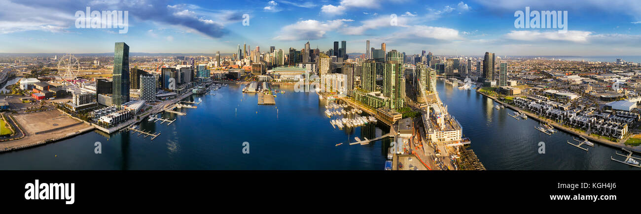 Antenne breites Panorama von Melbourne Docklands über den Fluss Yarra Gewässer mit Marina Yachten und Kaianlagen. Moderne urbane hoch aufragenden Türmen und Architektur Stockfoto