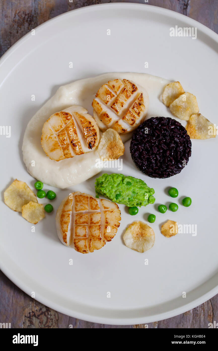 Jakobsmuscheln mit topinambur Püree, schwarzem Reis und Erbsen Brei ...