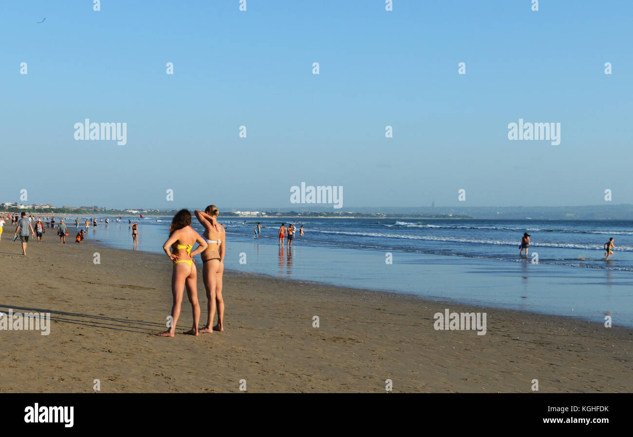 Jungen kaukasischen Frauen stehen und Bräunen am Strand von Kuta, Bali. Stockfoto