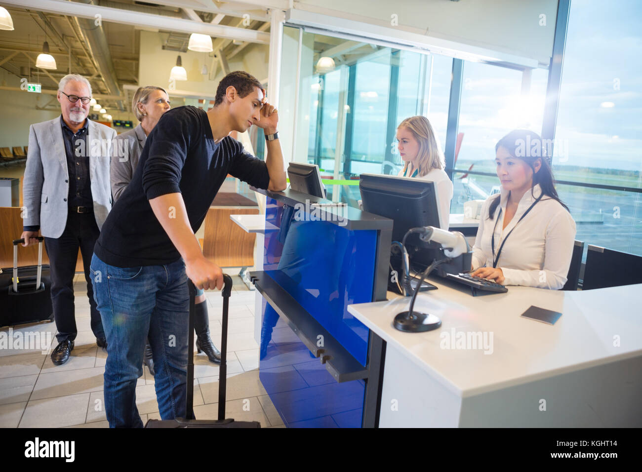 Die Verwendung von Computern während Passagiere am Flughafen warten Personal Stockfoto