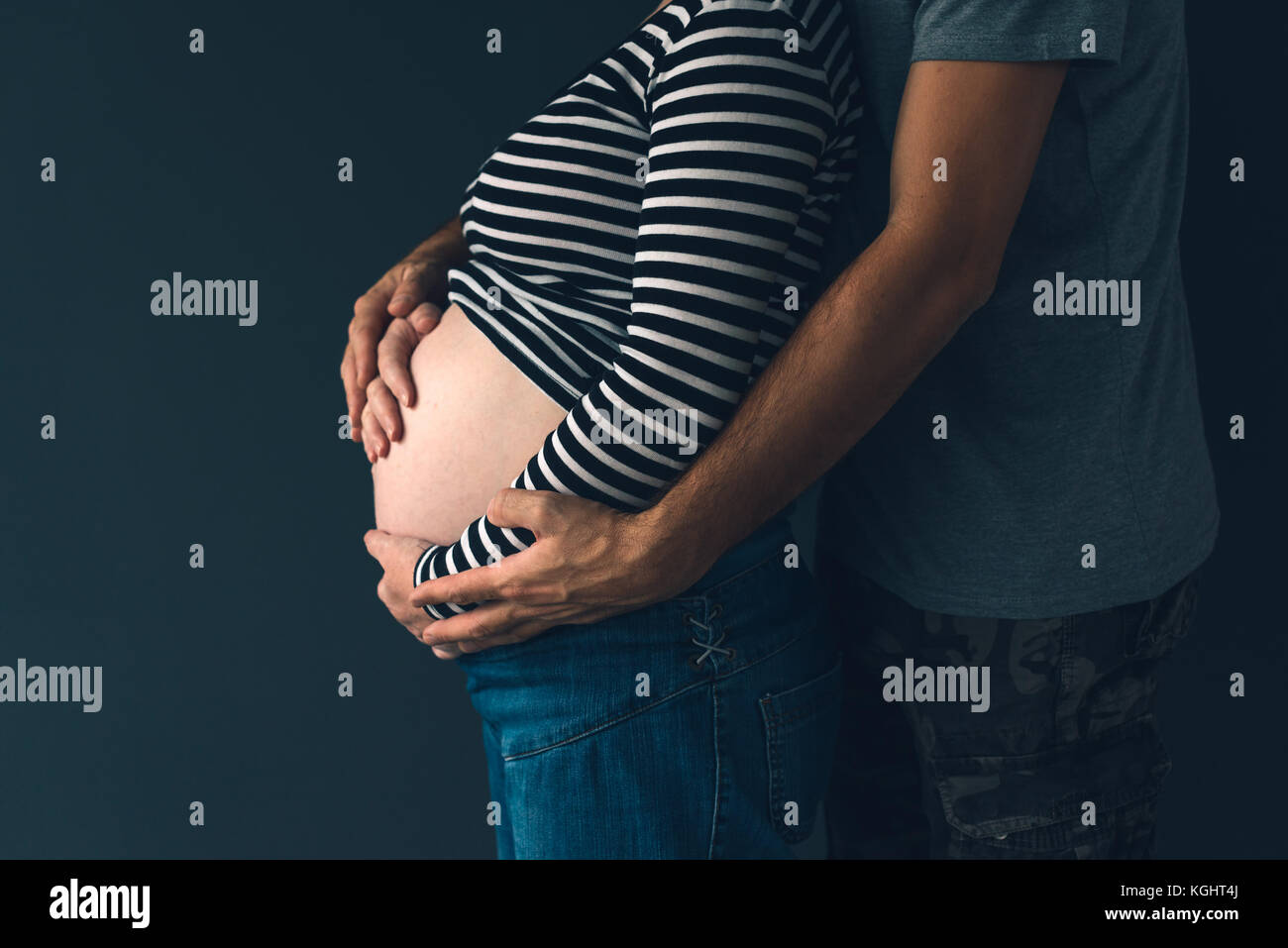 Soldat seine schwangere Frau umarmen, Paar erwarten Baby, Low Key Stockfoto