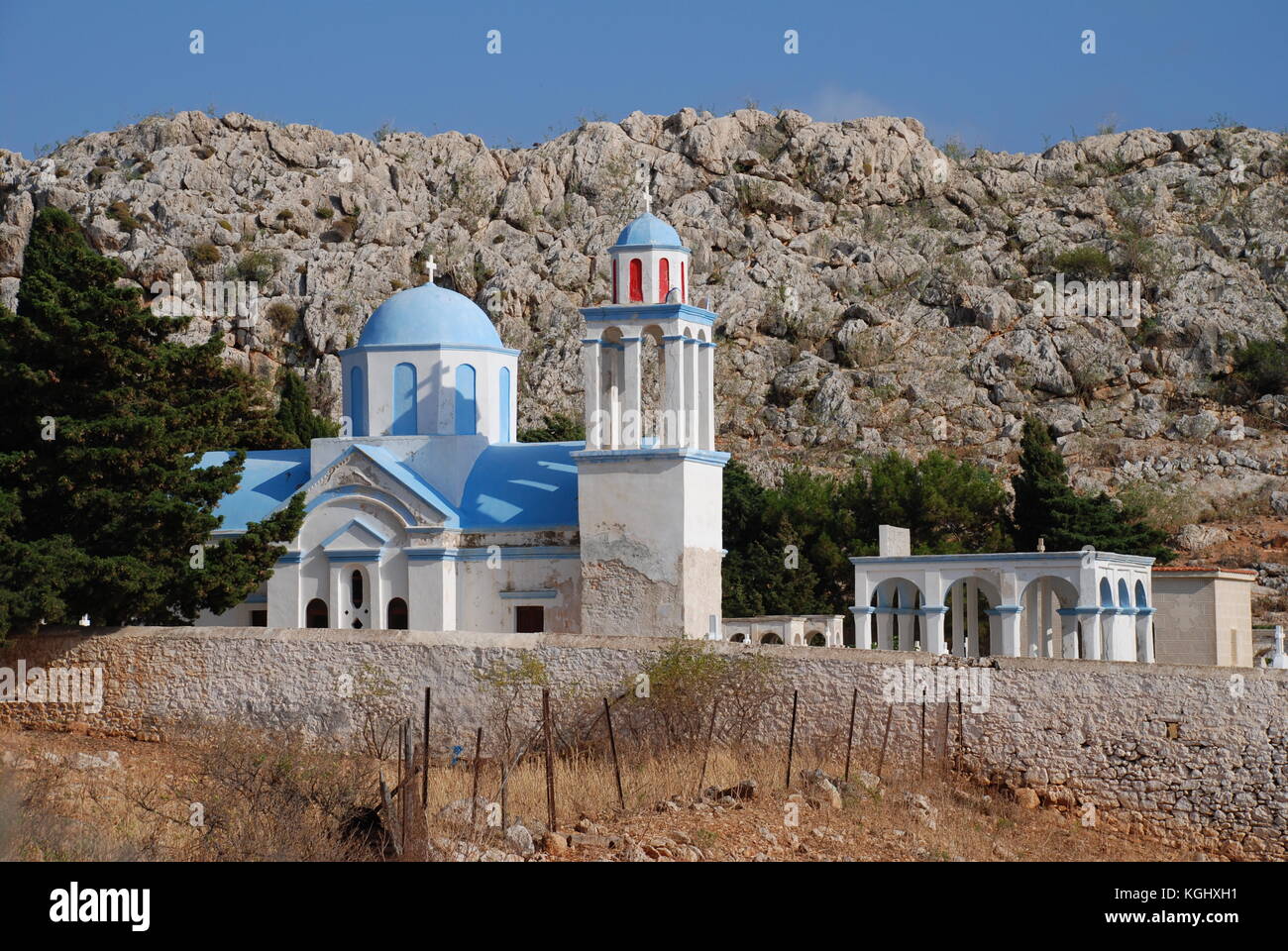 Die blauen Kuppeln der Kirche auf dem Friedhof von emborio Dorf auf der griechischen Insel Chalki. Stockfoto
