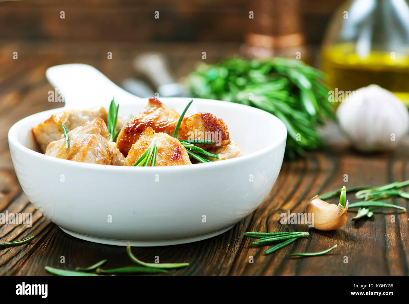 gebratenes Fleisch in Schüssel geben und auf einem Tisch Stockfoto