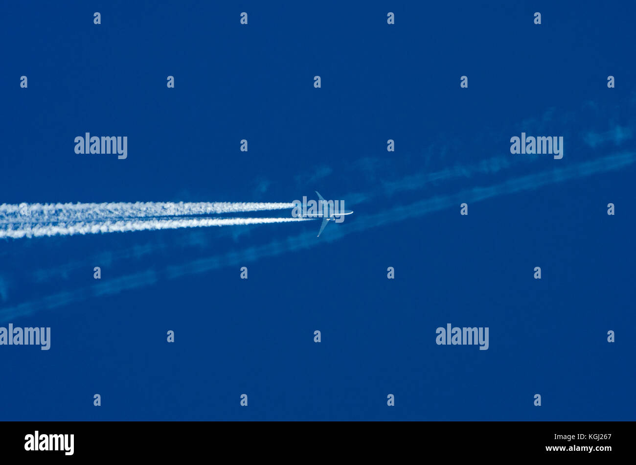 Transport Wettbewerb Konzept: ein Düsenflugzeug Kreuzung weißen Kondensstreifen gegen den blauen Himmel Hintergrund mit Kopie der anderen Ebene Stockfoto
