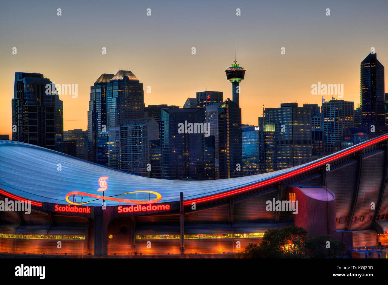 Calgary, Kanada - 23. Mai 2015: Sonnenuntergang über der Skyline von Calgary mit der Scotiabank saddledome im Vordergrund. die Kuppel mit ihrer einzigartigen Sattelform Stockfoto