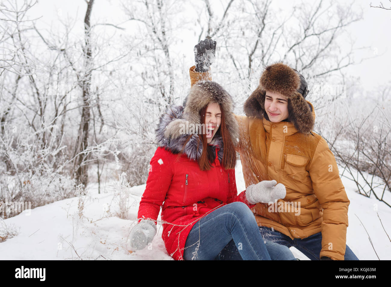 Verliebtes Paar. Jugendliche an einem Tag im Winter von drinnen nach draußen. Er Schnee auf seine Freundin weh. Sie lacht. die Freude der Begegnung. Stockfoto