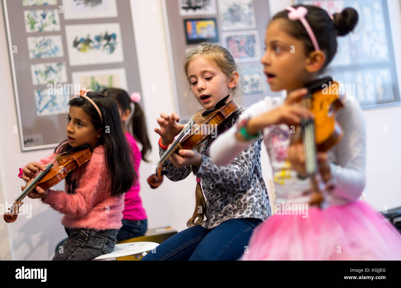 Dresden-Prohlis, Deutschland. Oktober 2017. Der 7-jährige Raghad (L-R), der 7-jährige Lamar und der 8-jährige Hala spielen Geige während des Musikunterrichts im Rahmen des Projekts Musaik in Dresden-Prohlis, Deutschland, 26. Oktober 2017. Kinder, denen sonst der Zugang zu einer Musikausbildung entzogen würde, werden in diesem Projekt für soziale Musik unterrichtet. Quelle: Monika Skolimowska/dpa-Zentralbild/dpa/Alamy Live News Stockfoto