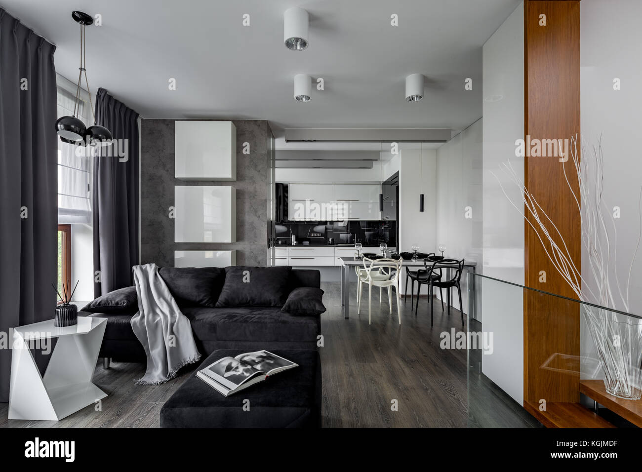 Grau-weiße Wohnung mit Wohnzimmer, offen zur Küche Stockfoto
