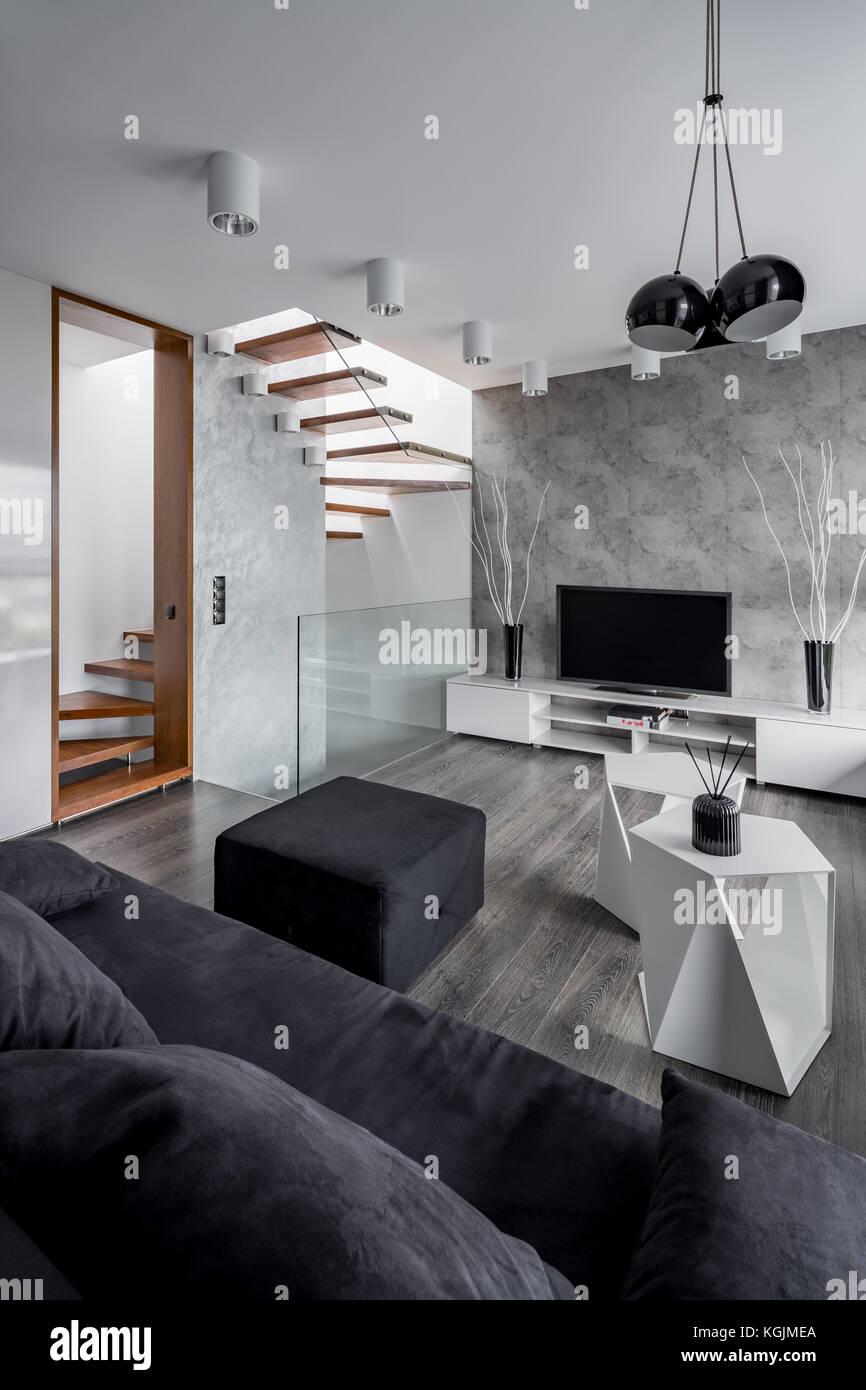 Elegantes Wohnzimmer mit Couch, tv, Tisch und Treppe Stockfoto