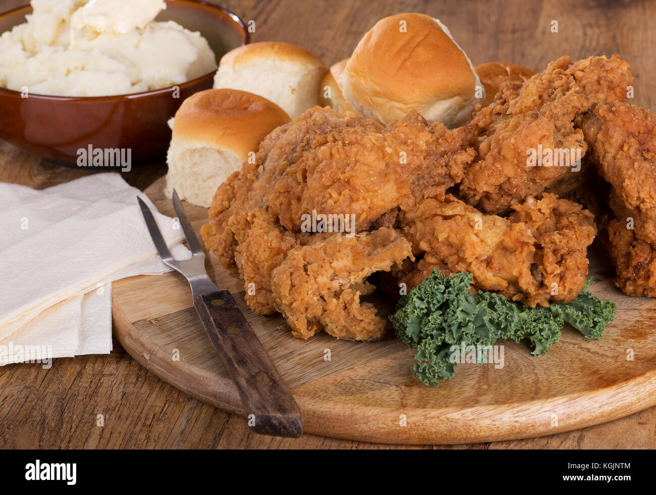Gebratenes Huhn auf einer Servierplatte mit Kartoffelpüree und Rollen Stockfoto